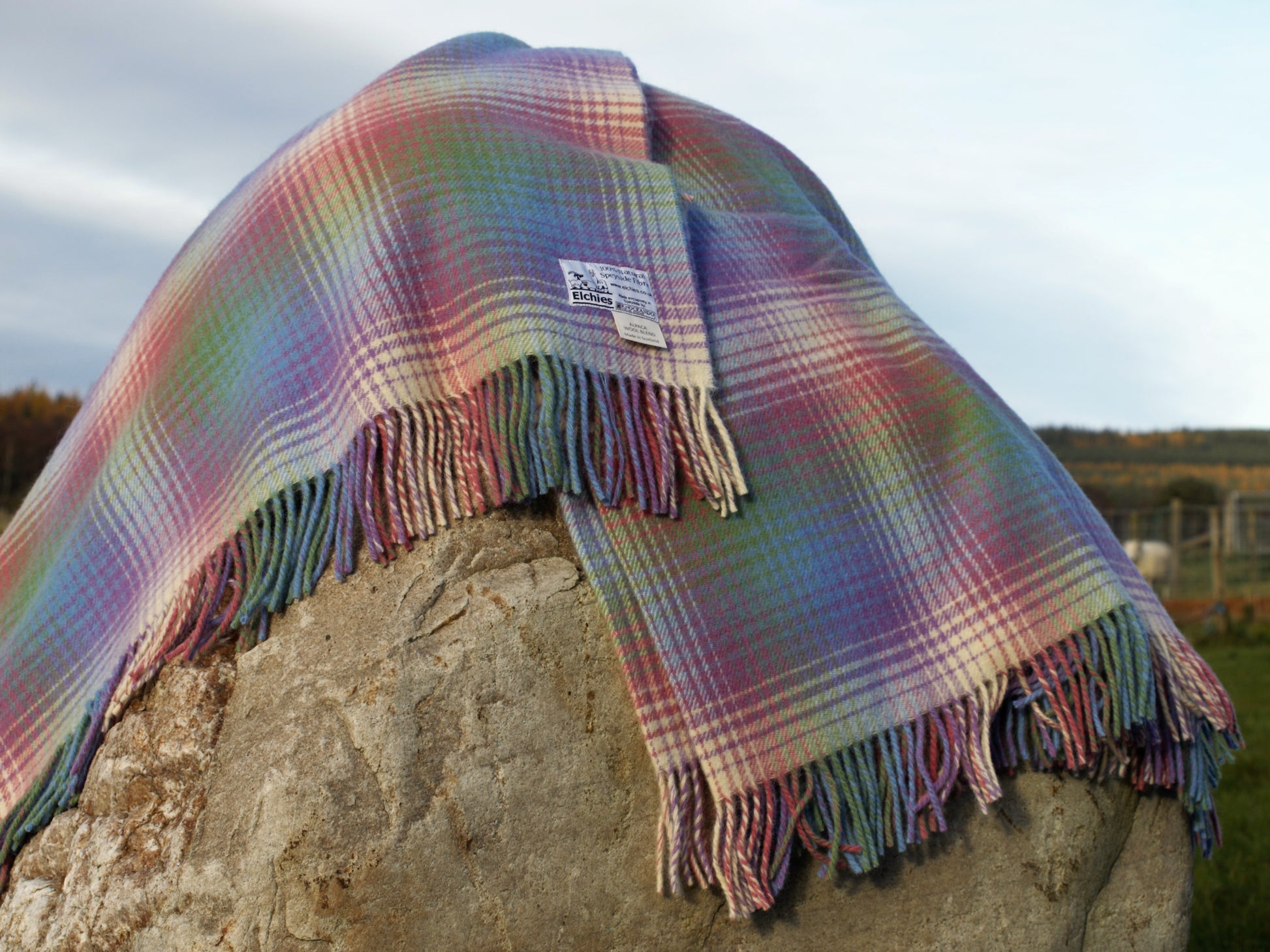 The Elchies Farm 'Borealis Wool Blanket' draped on a rock in the sun.