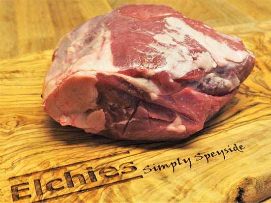A portion of bone in leg joint goat meat displayed on a branded Elchies wooden board. 