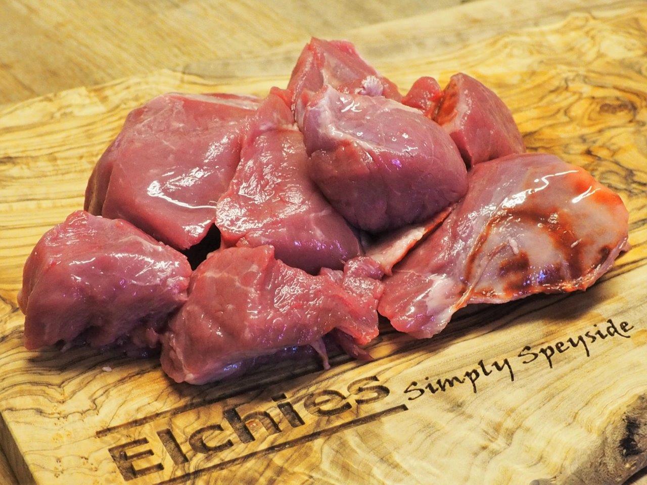 A portion of diced goat leg meat displayed on a branded Elchies wooden board. 
