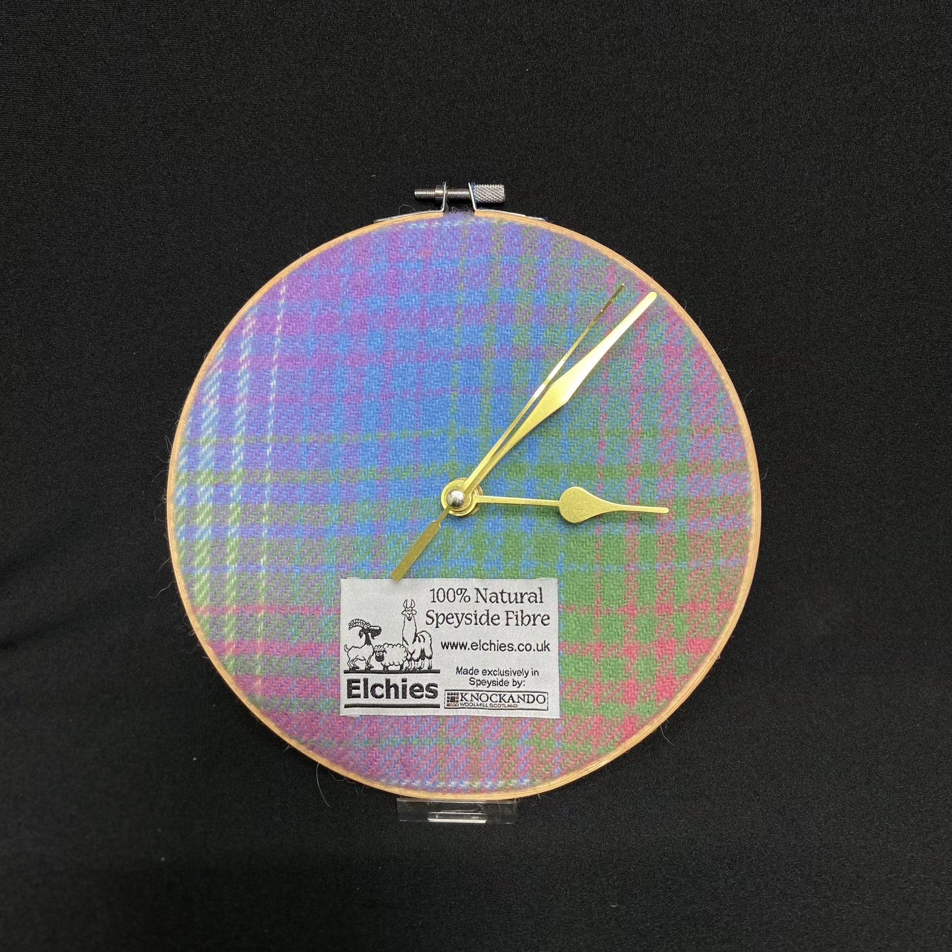 A close-up of the circular Elchies Farm 'Borealis Wool Clock' framed in an embroidery hoop.