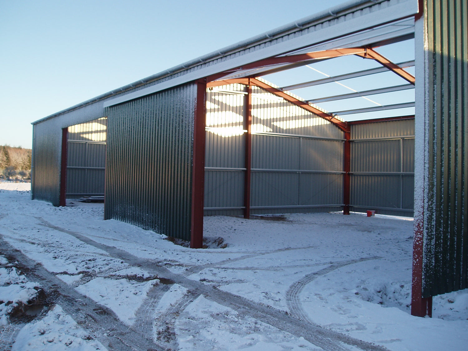 New metal barn with snow on the ground.