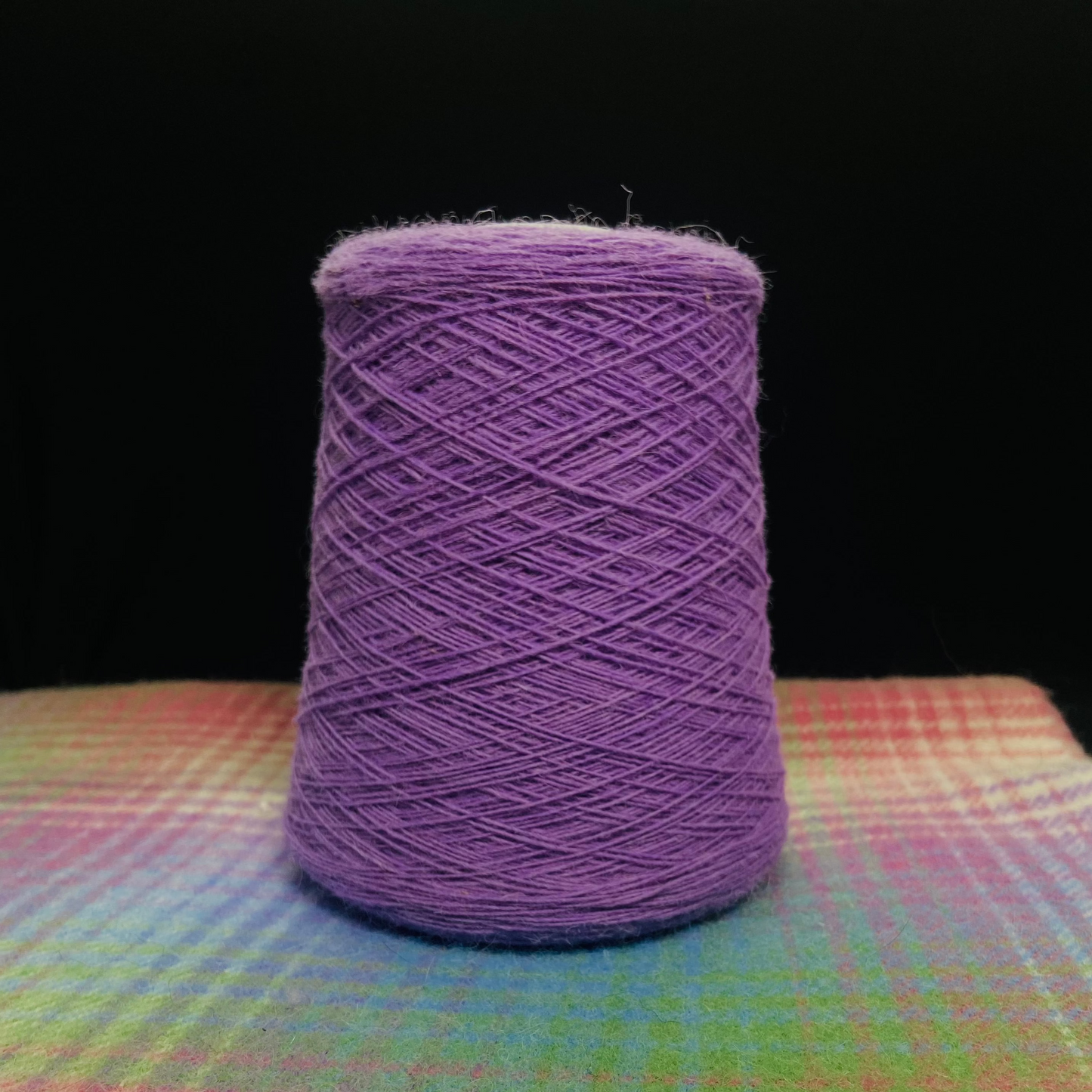 A cone of Elchies Farm Wool in the shade 'Lavender'.