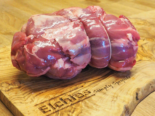 A portion of boned and rolled goat leg meat displayed on a branded Elchies wooden board. 